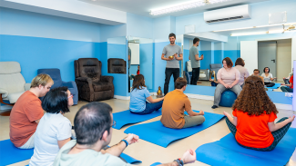 People in a hall performing exercises on mats 