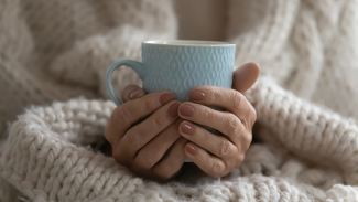 Hands around a cup to keep warm